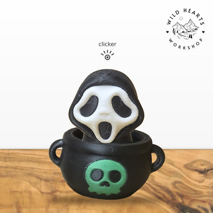 Scream Mask clicker top (Scream mask ghost) seated in the black cauldron with green skull base