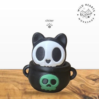 Skeleton Cat clicker top (skeleton cat) seated in the black cauldron with green skull base