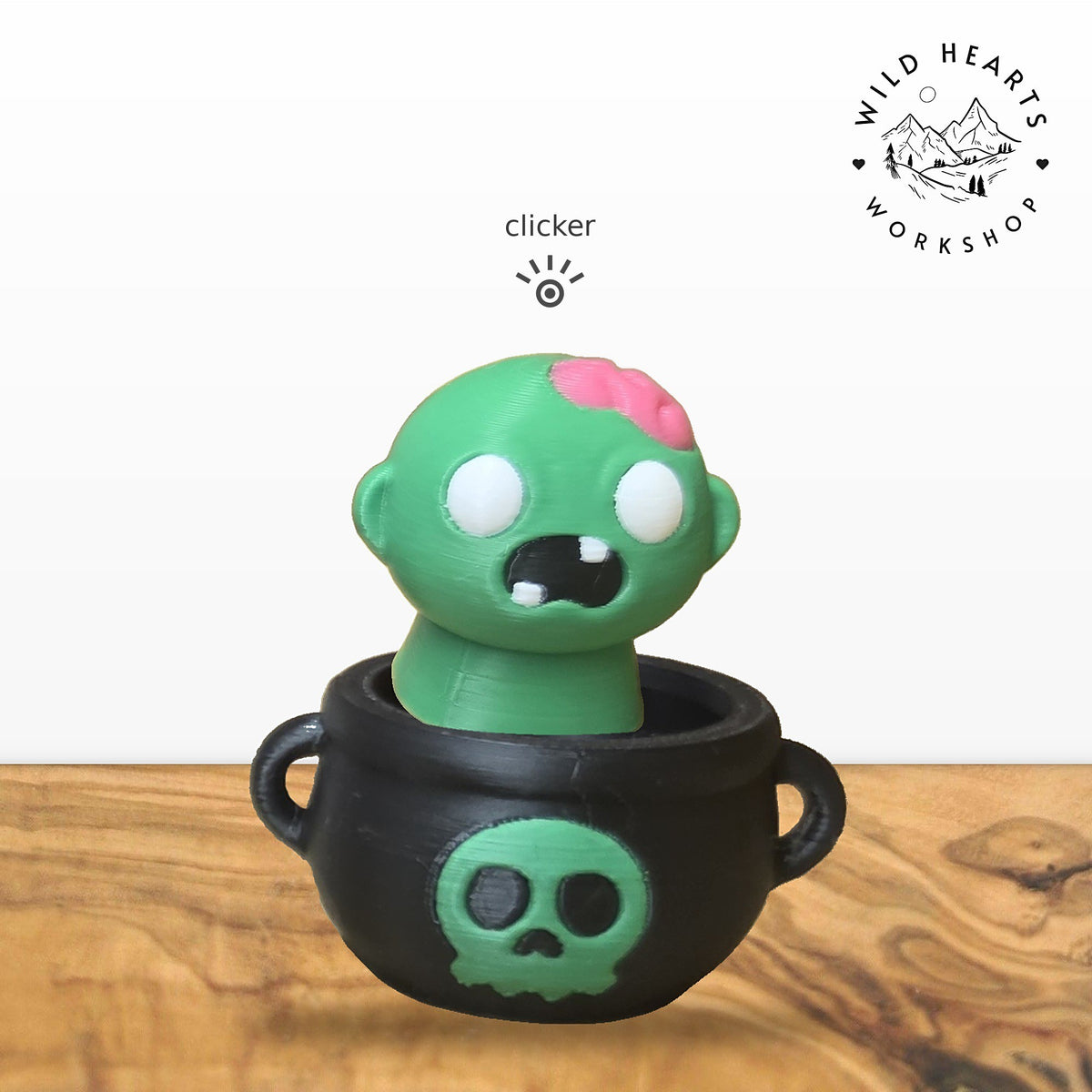 Zombie clicker top (green zombie with pink brain) seated in the black cauldron with green skull base