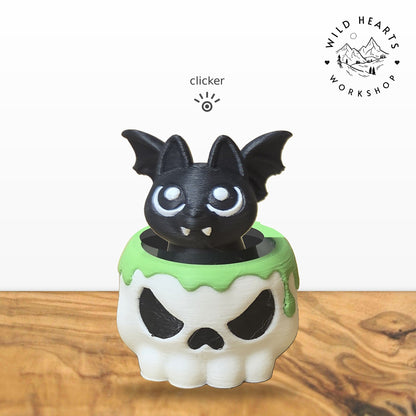 Bat clicker top (black bat) seated in the white skull pot with green slime rim base