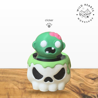 Zombie clicker top (green zombie with pink brain) seated in the white skull pot with green slime rim base